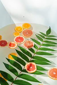 橙子、柠檬、葡萄柚果实在水中，绿叶。