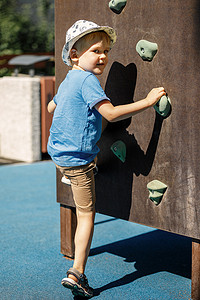 小男孩和游乐场的攀岩墙