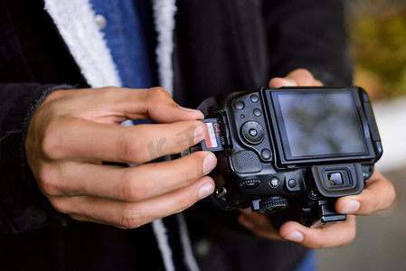 摄影师手持存储卡 — 专业数码单反相机附近的闪存卡