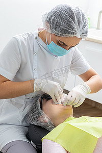 牙医在牙医办公室安装患者脸颊牵开器