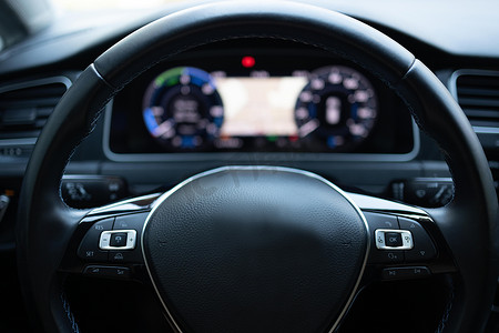 新型电动汽车方向盘、内部驾驶舱、电动按钮、数字车速表的特写。