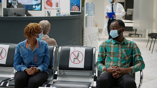 戴口罩的非裔美国患者在等候区说话