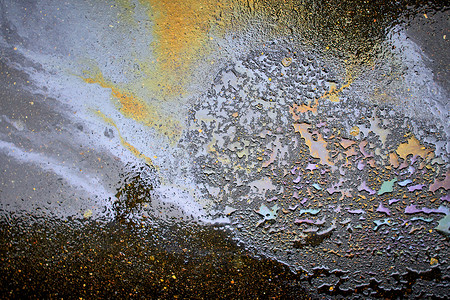 流体彩色摄影照片_沥青上的油污，沥青路上彩虹形的彩色汽油污渍