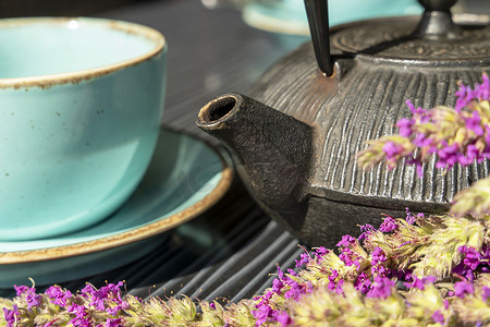 咖啡馆桌子上的绿松石杯热茶和小茶壶