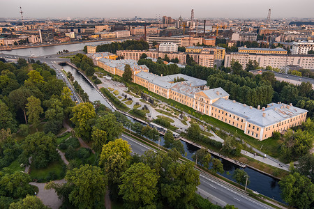 俄罗斯日落时圣彼得堡卡尔波夫卡河堤公园的鸟瞰图、休闲区、长凳和露天剧场、公园对面的植物园