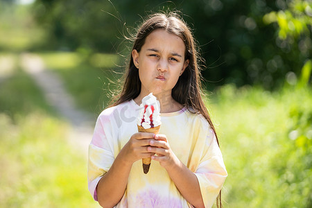 漂亮的小女孩拿着冰淇淋，脸色愤怒，消极