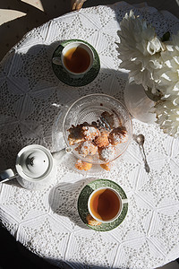 英式茶歇，早晨阳光下的静物画，鲜花和甜甜圈