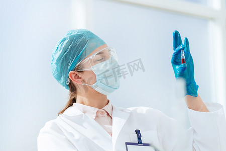 一位女科学家手中装有疫苗的安瓿。