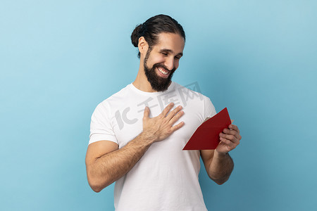 男人从红包里读信，收到贺卡，有积极的浪漫表情。