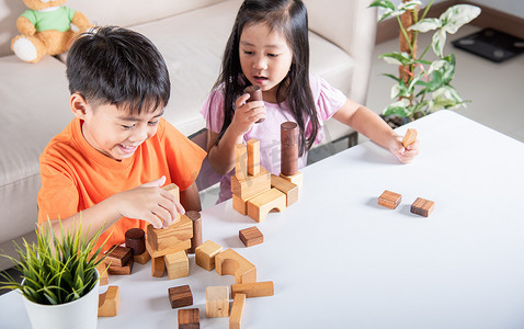 儿童男孩和女孩玩建造者木块建筑