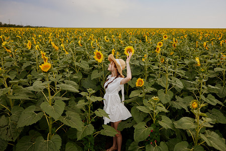 向日葵摄影照片_戴着草帽、穿着白色连衣裙的女人肖像向日葵农业田夏季