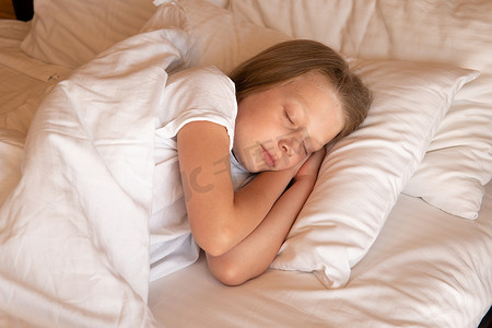 睡眠手机美丽的年轻女孩床毯视图躺着，概念女性细胞为人和平静的休息，房间的美丽。