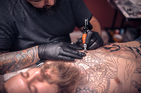 在纹身工作室使用专业纹身机设备的纹身师