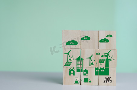 具有净零和碳中性绿色工厂图标符号背景和复制空间的木制立方体。