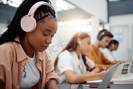 教育、耳机和大学里的黑人女性用笔记本电脑、打字笔记和学习考试。
