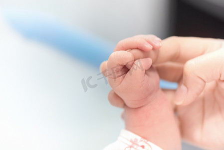 新生儿手握母亲手指在医院、婴儿和保健概念、选择性焦点和白色小插图