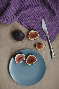 静物画，桌上有成熟的新鲜无花果、刀和紫色纺织品