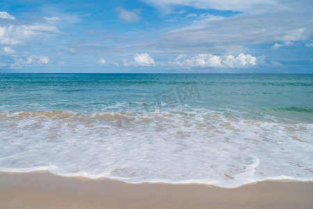 热带自然干净的海滩和白色的沙滩在夏天与阳光浅蓝色的天空和散景。