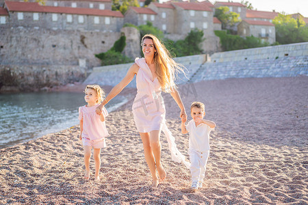 母亲和两个孩子的女儿和儿子游客以美丽的景色为背景，圣斯蒂芬岛，圣斯蒂芬岛，位于黑山布德瓦的布德瓦里维埃拉。