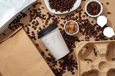 纸杯包装设计摄影照片_空白棕色牛皮纸袋，配有咖啡豆和纸杯，适合您的设计