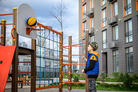 孩子的手图标摄影照片_一个男孩在篮球场上打篮球的肖像。