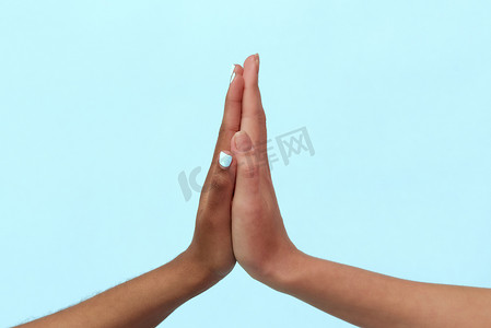 白人和黑人非裔美国妇女的手在蓝色背景下互相赠送五张。