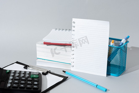 重要信息显示在桌子上的笔记上，周围有铅笔、书籍、剪贴板和计算器。