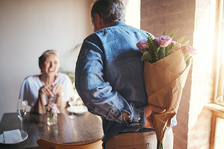 惊喜、鲜花和年长夫妇在餐厅庆祝周年纪念日、结婚或生日。