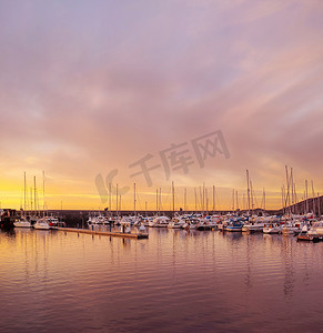 挪威博多日落时停靠在水港的私人游艇的风景。
