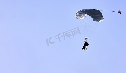 蓝天白云免费下摄影照片_一名跳伞运动员，在蓝天白云的映衬下，带着白色降落伞罩，特写。