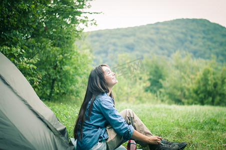 帐篷附近山中的女人享受大自然