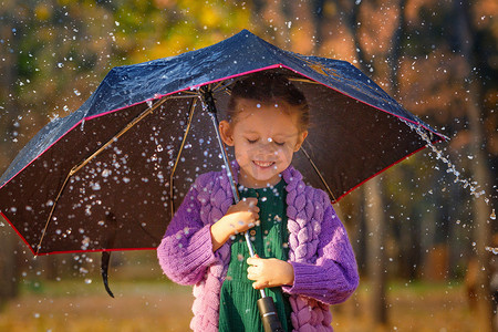 下雨打伞摄影照片_秋季公园蘑菇雨下打伞的女孩