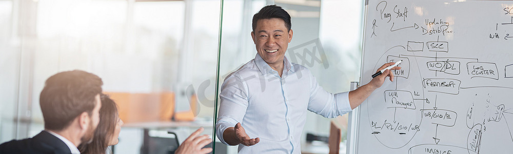银行工作摄影照片_成熟的亚洲教练或演讲者在会议上向不同的商人做活动挂图演示