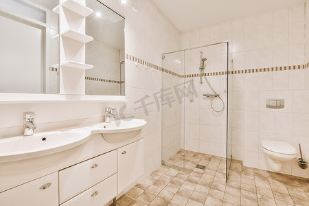 卫生间装饰摄影照片_现代浴室配有淋浴、水槽和卫生间