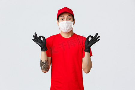 忧心忡忡的年轻亚洲送货员试图安抚紧张的客户，表现出禅宗姿态，戴着医用口罩和防护手套，穿着公司制服。