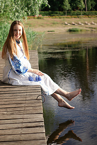 湖岸码头上穿着乌克兰民族刺绣服装的女孩。