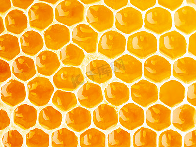甜摄影照片_蜂巢特写，新鲜的细丝滴甜蜂蜜，宏观背景