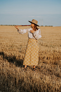 在麦田里吹木管乐器木笛-乌克兰特连卡或泰林卡的妇女。