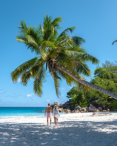 塞舌尔普拉兰岛安斯乔吉特，一对年轻夫妇在塞舌尔的热带海滩上享受豪华假期。