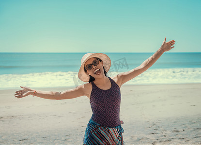 戴帽子的女人在海滩上快乐，快乐的漂亮年轻女人度假，度假概念