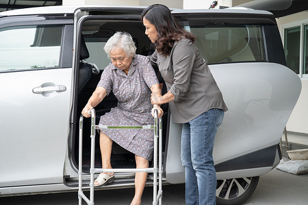 护理人员女儿帮助和支持亚洲老年或老年老妇女病人准备下车。
