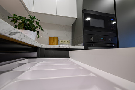 缩回摄影照片_现代白色和深灰色厨房的大理石台面