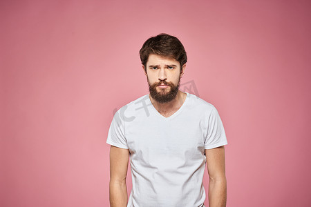 穿着白色 T 恤的男人情绪生活方式面部表情裁剪视图粉红色背景。