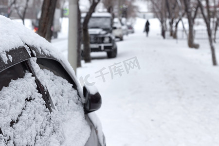 雪阴天有雪花的客车，雪关闭的侧门，冷雪时的城市景观