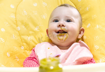 宝宝穿棉衣服摄影照片_宝宝正在吃蔬菜泥。