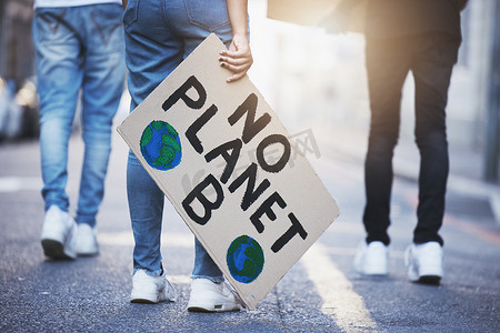 人们举着气候变化海报或横幅在柏油路、街道或城市上抗议。