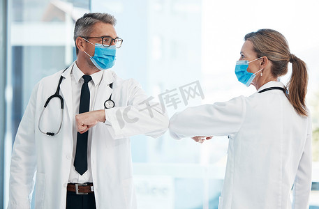 医生用肘部进行新冠病毒安全问候，戴口罩以防止病毒感染，并在医院工作。