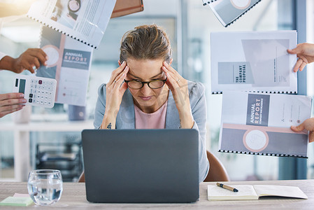 一位女性领导者、经理和首席执行官在办公室使用笔记本电脑处理多项任务时感到工作过度，感到压力、焦虑和倦怠。