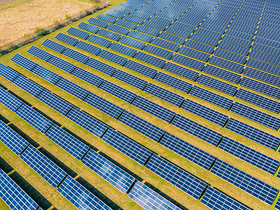 模块摄影照片_德国农村地区带有太阳能电池板的光伏地面安装系统旁边的农业