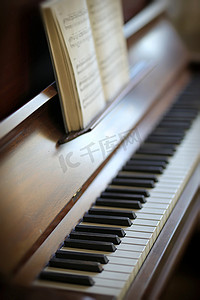 卡通小人弹钢琴摄影照片_老式钢琴和键盘的特写镜头与乐谱书。